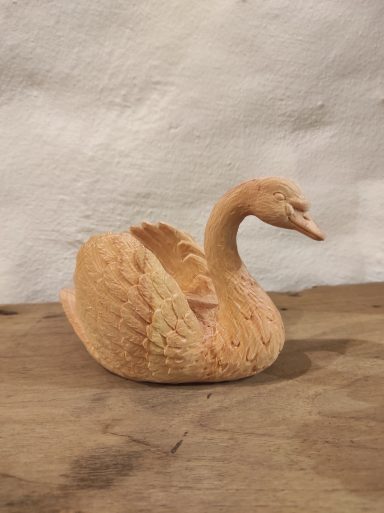 Schwan Ein kunstvoll geschnitzter Schwwan aus Holz mit detaillierter Federstruktur.